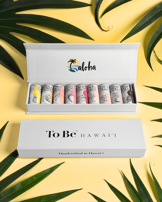 Set of nine handcrafted mini lip butters in a box with 'To Be Hawaii' branding on a yellow background with green leaves.