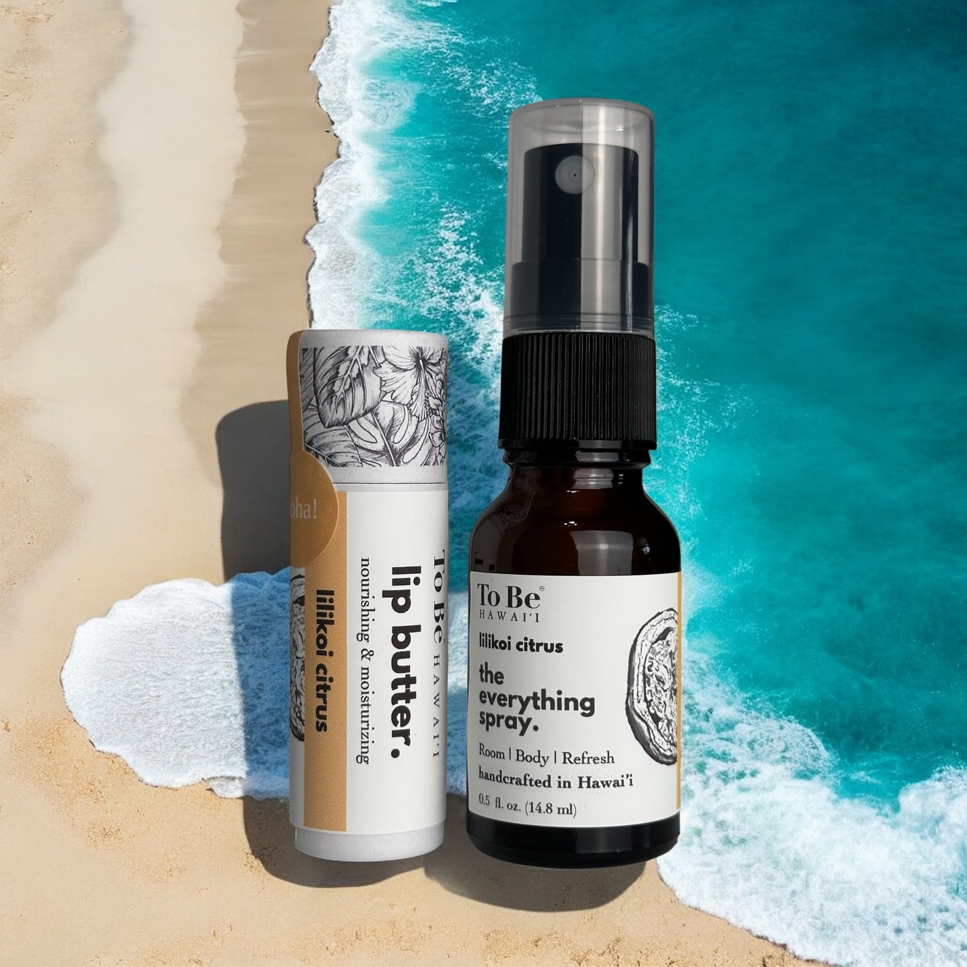 Two products, a lip butter and a spray bottle, on a beach with ocean waves in the background.