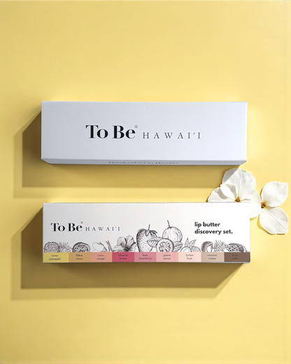 Two 'To Be Hawaii' lip butter boxes on a yellow background with white flowers.